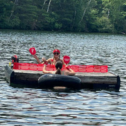 girls swimming in lake playing pepper pong on wooden floating dock
